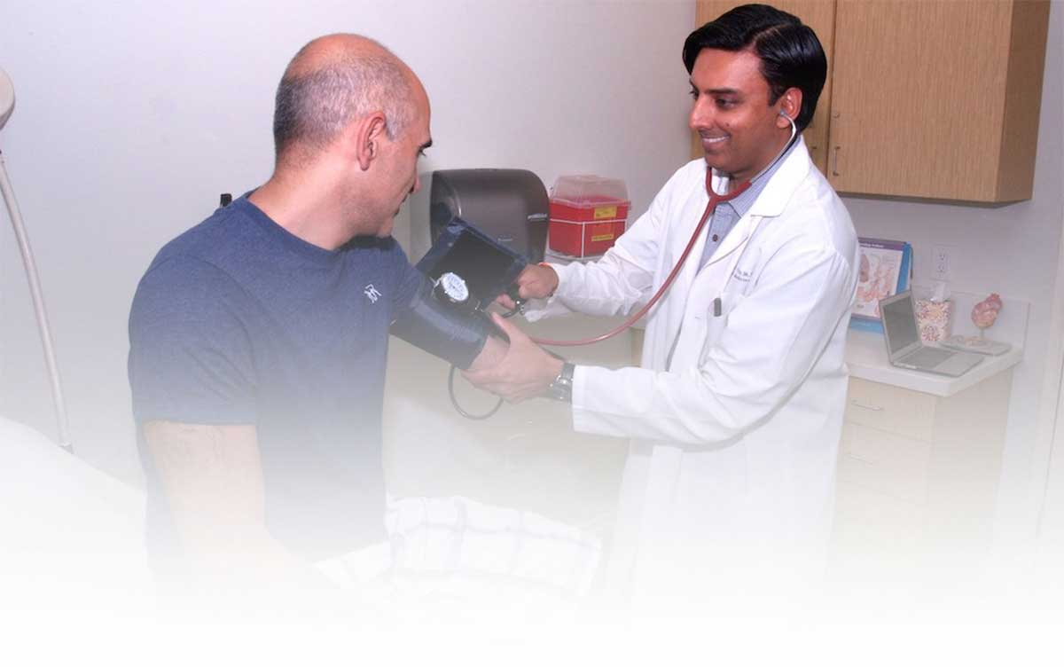 Dr Paresh N. Varu, MD checking patients blood pressure.